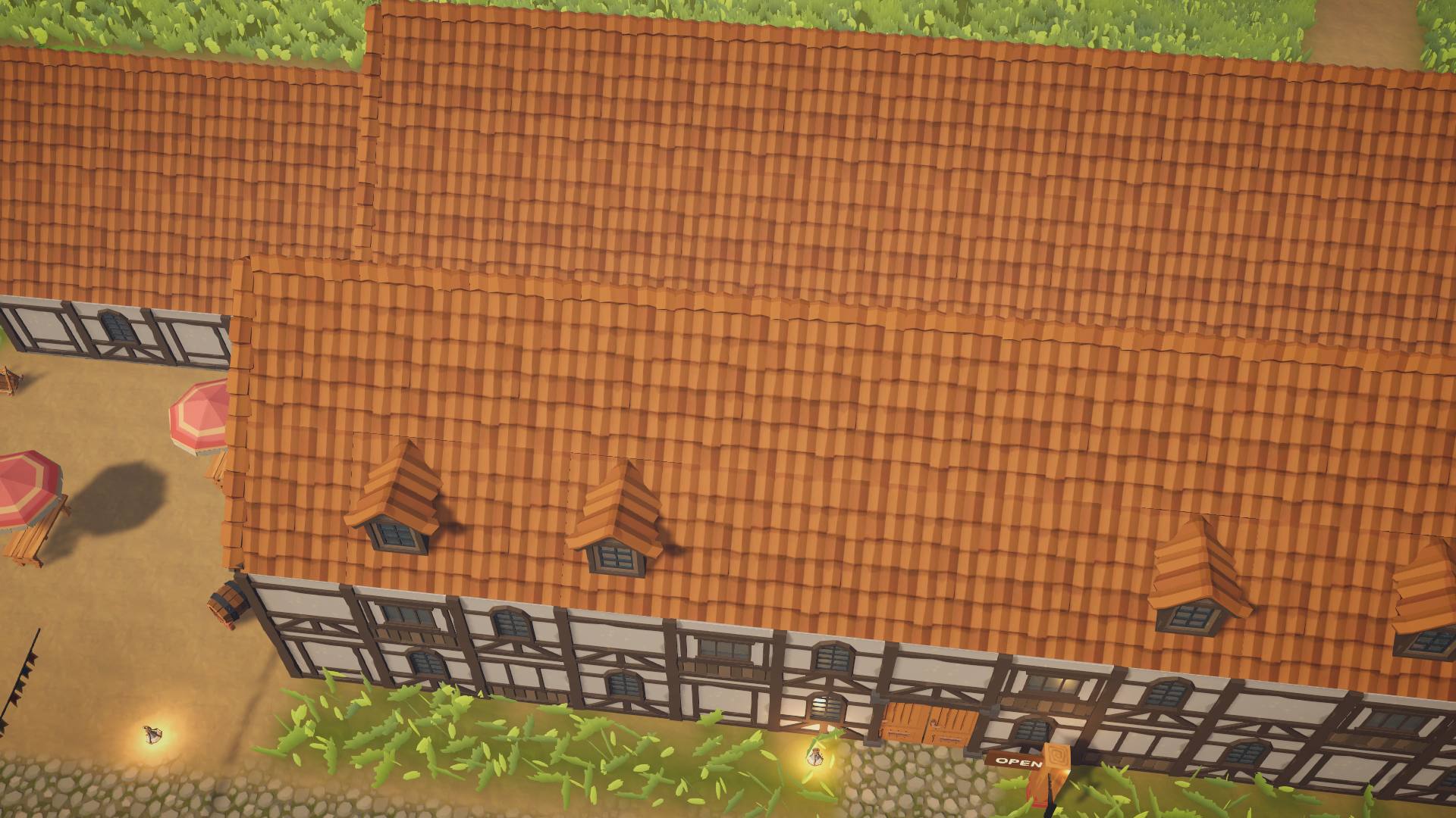 The tavern's long tiled roof and timbered front from above, with an Open sign by the door